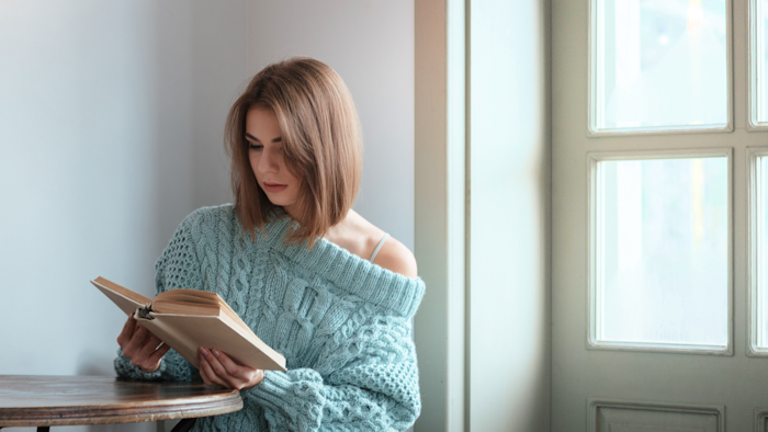 Woman Reading Next to Window