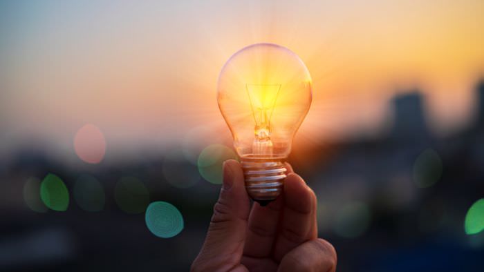 Hand holing clear light bulb